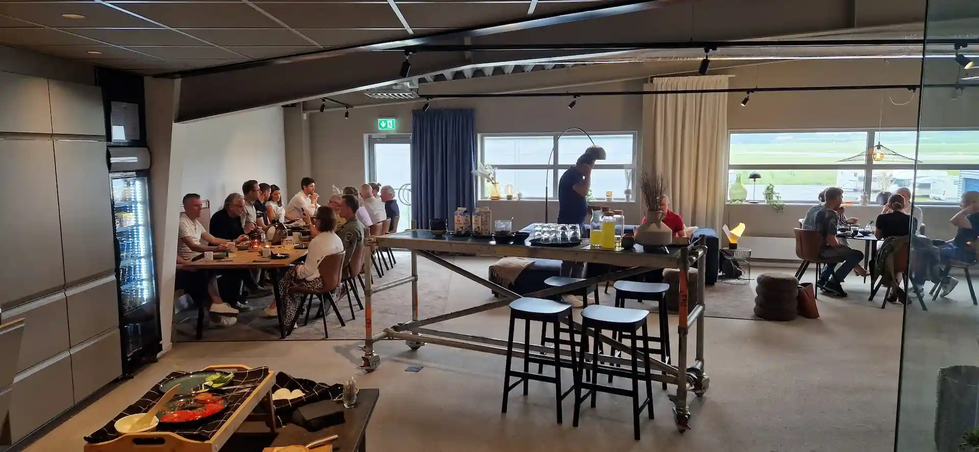 Många gäster samlas vid bord i en lounge för att delta i ett evenemang för våra hyresgäster.